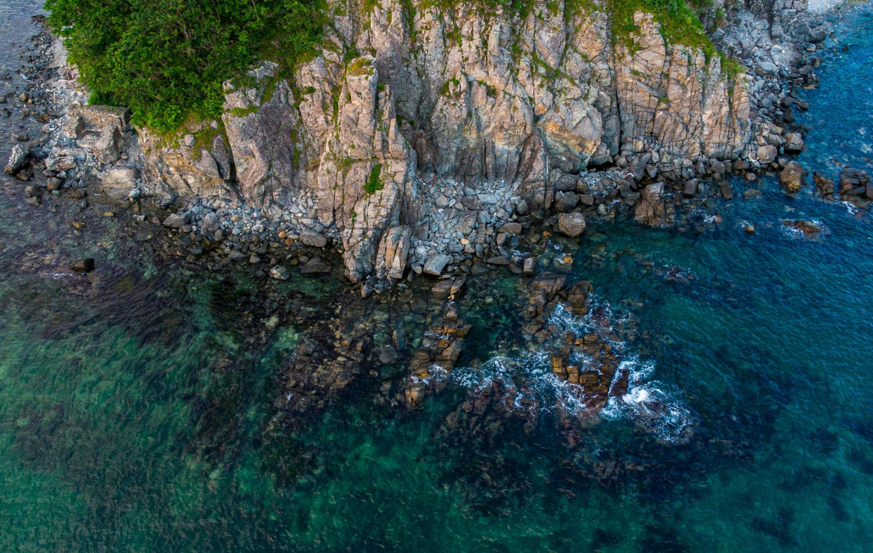 https://unsplash.com/photos/brown-and-green-rocky-mountain-beside-body-of-water-during-daytime-KjVqEPaptKg