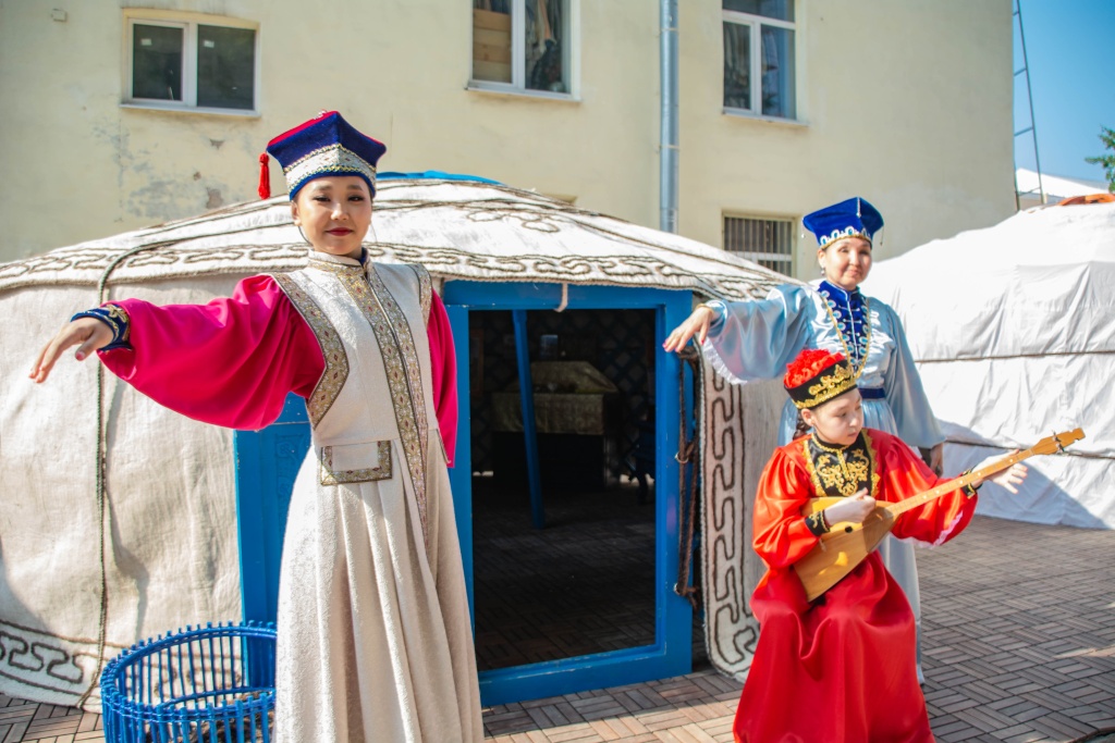 Калмычки танцуют народный танец Ишкимдык. Девушка в красном играет на домре. Фото: Ирина Иванова.