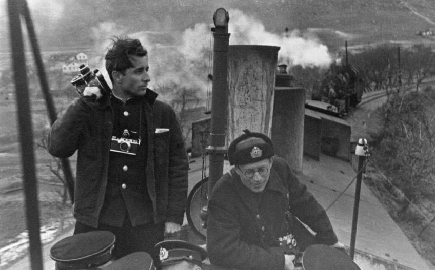 Неиз­вест­ный автор. Ин­же­нер-ка­пи­тан III ранга Вла­ди­слав Ми­ко­ша, ки­но­опе­ра­тор ки­но­съе­моч­ной груп­пы По­лит­управ­ле­ния ЧФ и Дмит­рий Ры­ма­рев, ки­но­опе­ра­тор По­лит­управ­ле­ния ЧФ, на бро­не­по­ез­де «Же­лез­ня­ков». 1942. Се­ва­сто­поль, Ме­кен­зи­е­вы горы.